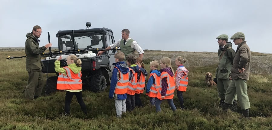 A group of children listening to a lesson in a grouse moor