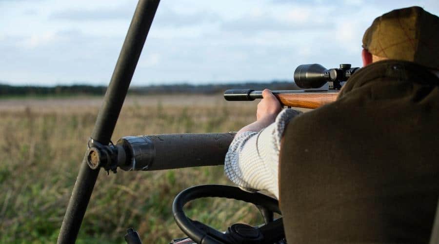 A shooter aiming down a rifle scope