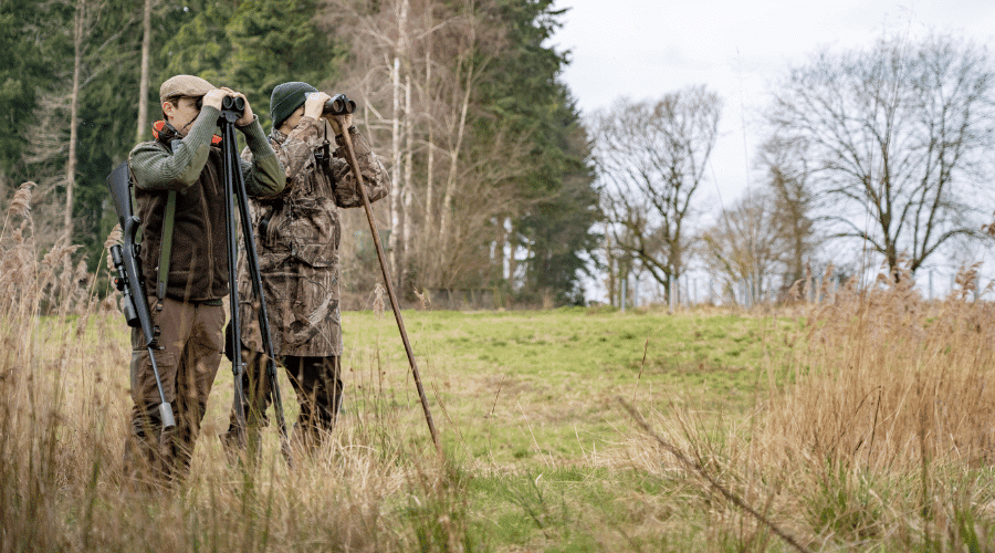 Deer stalkers looking through binoculars