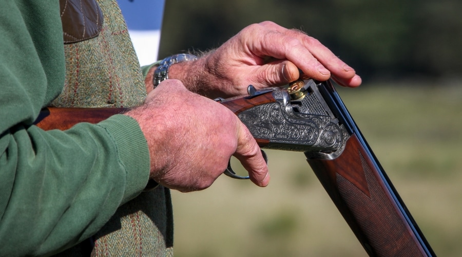 A shooter loading a shotgun