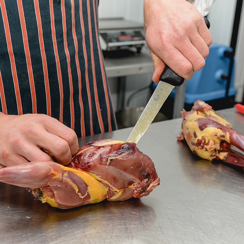 A game meat butcher preparing meat