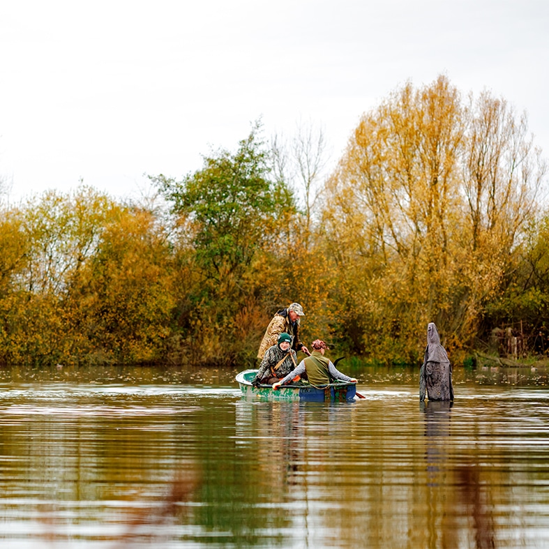 Wildfowlers in a small boat crossing water