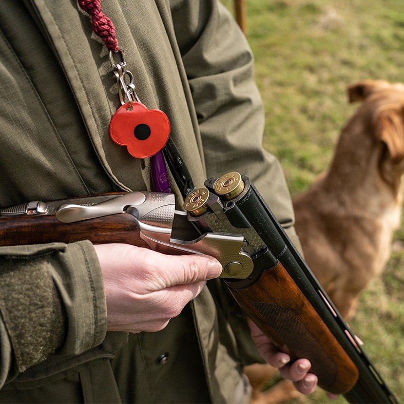 A shooter holding a broken shotgun