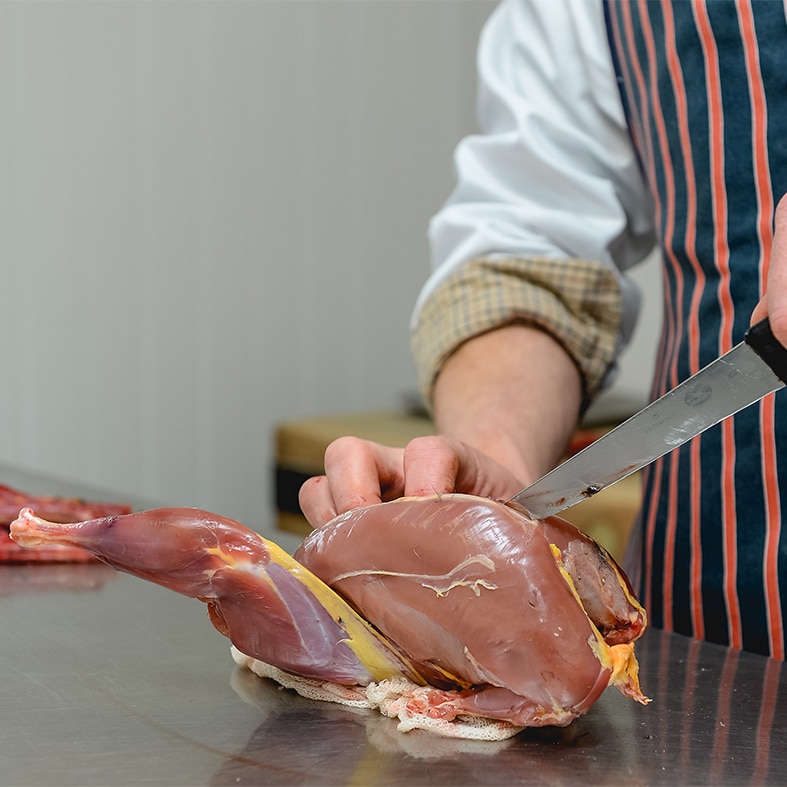 A chef preparing small game meat