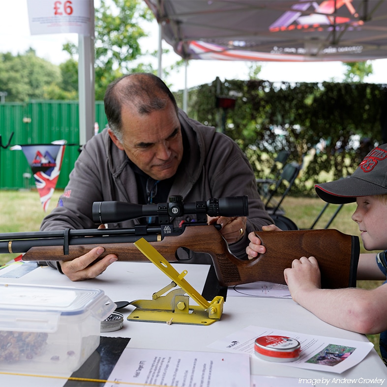 A young shot being coached with their air rifle