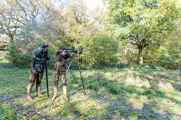 Deer stalkers looking through binoculars