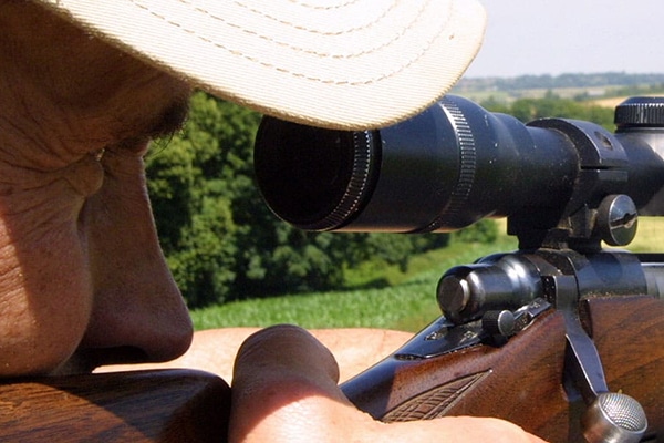 Rifle shooter aiming down a scope
