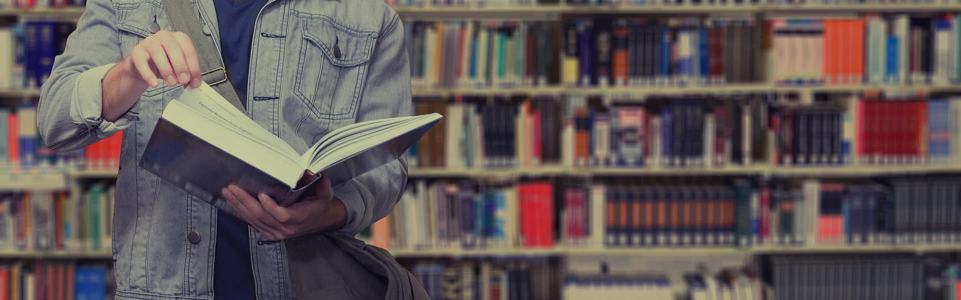 A man reading a book in a library