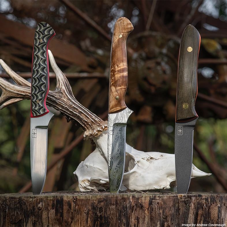 Three knives impaled into a log standing up straight