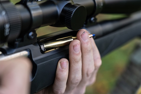 A bullet being loaded into a rifle