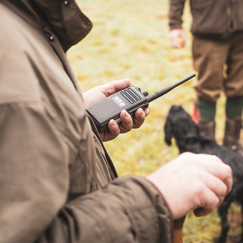 A game shooter holding a radio