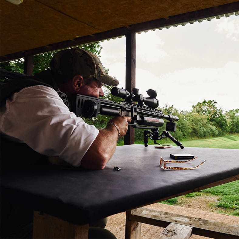 Air rifle shooter aiming down a range
