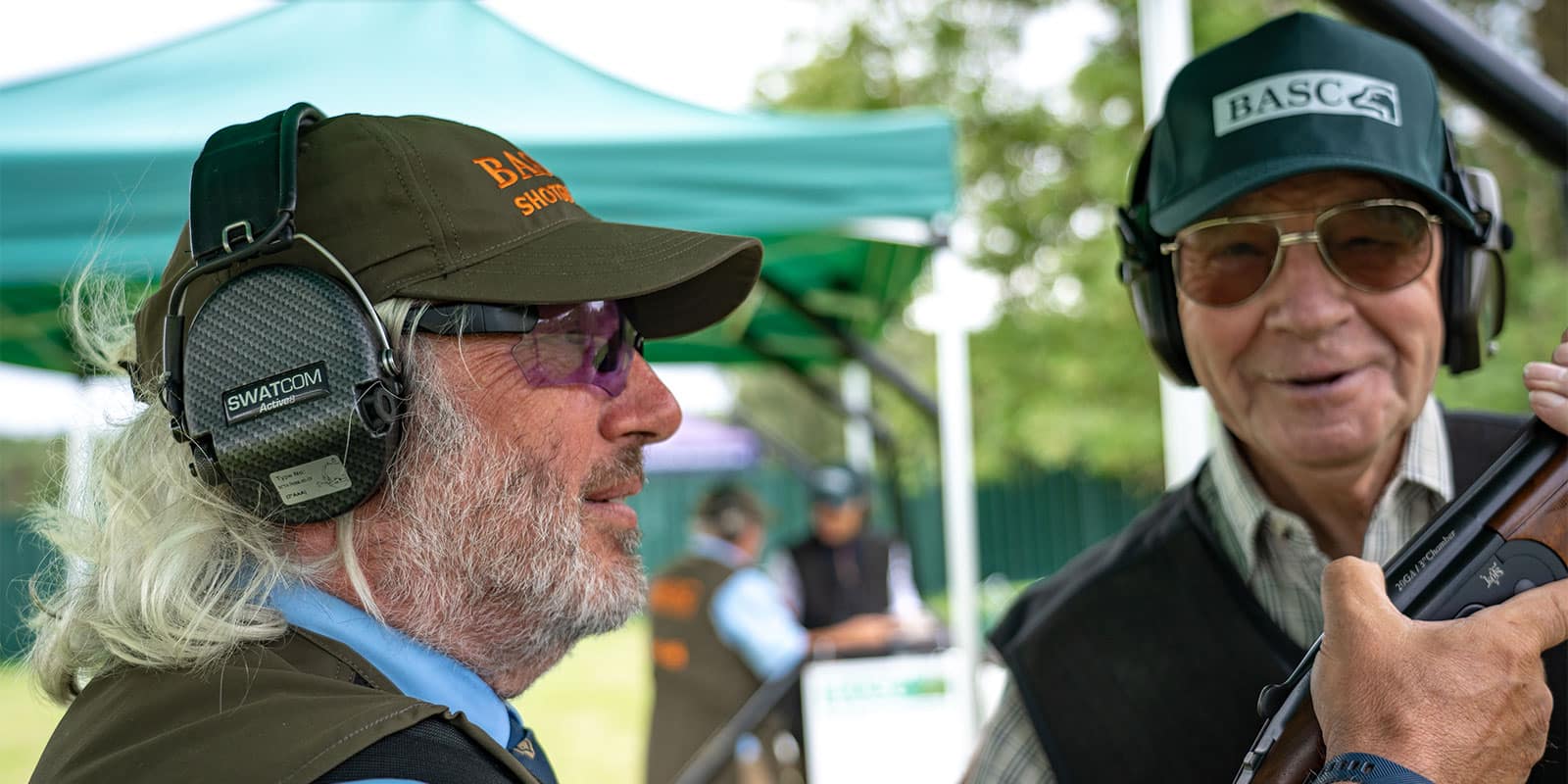 A close up of two shooters wearing SWATCOM ear protection