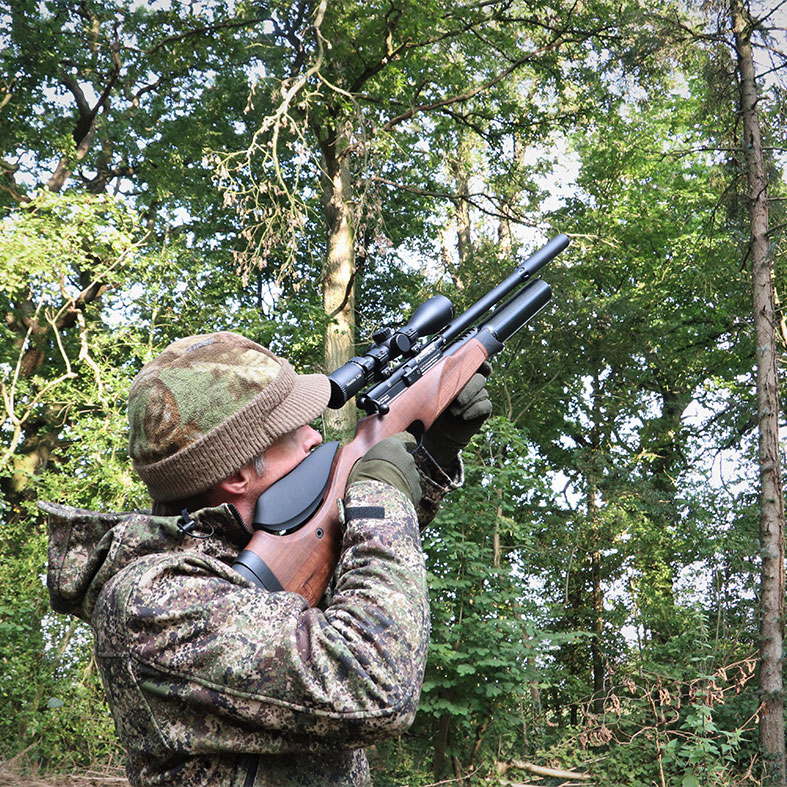 An airgun shooter aiming down the sight of their rifle