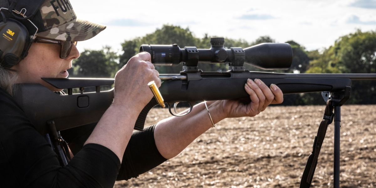 Woman shooting a rifle pulling the bolt back