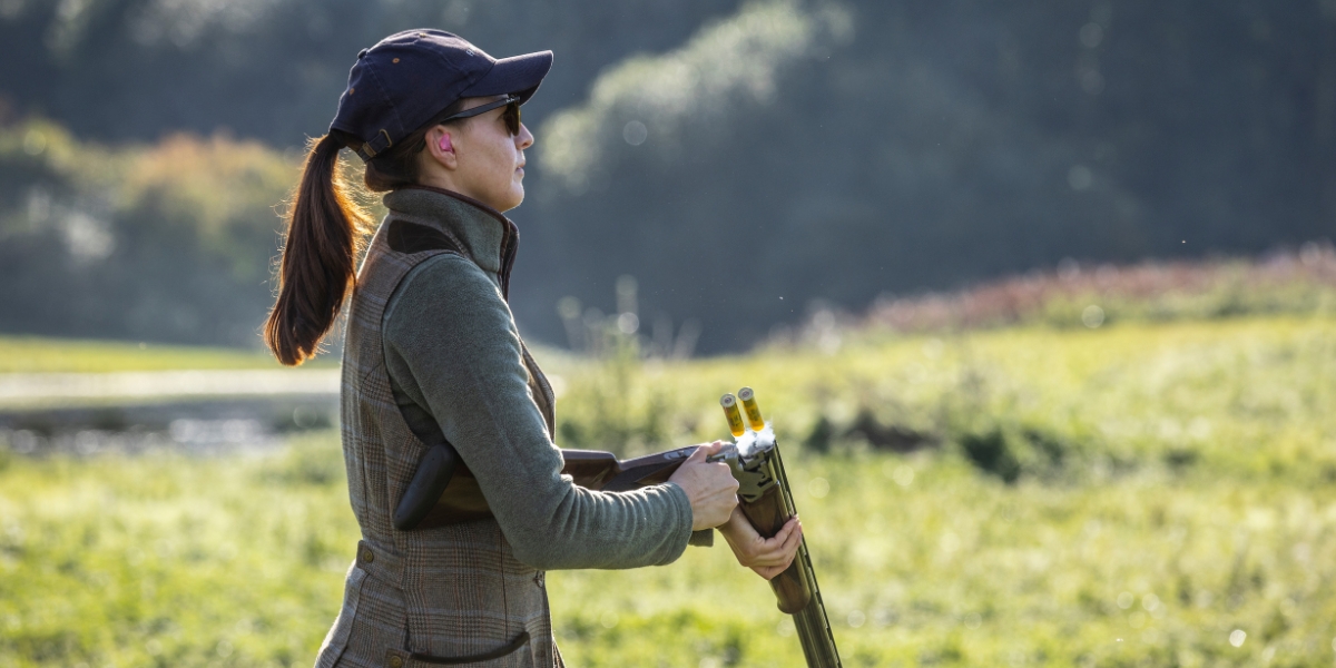 A woman unloading a shotgun