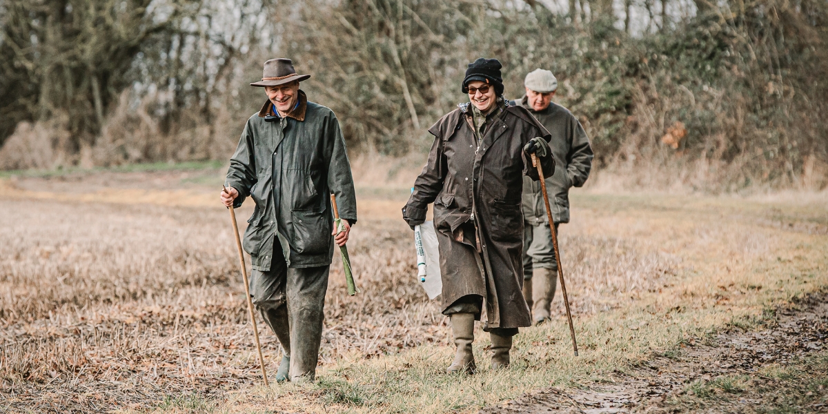 two beaters walking across a stubble field