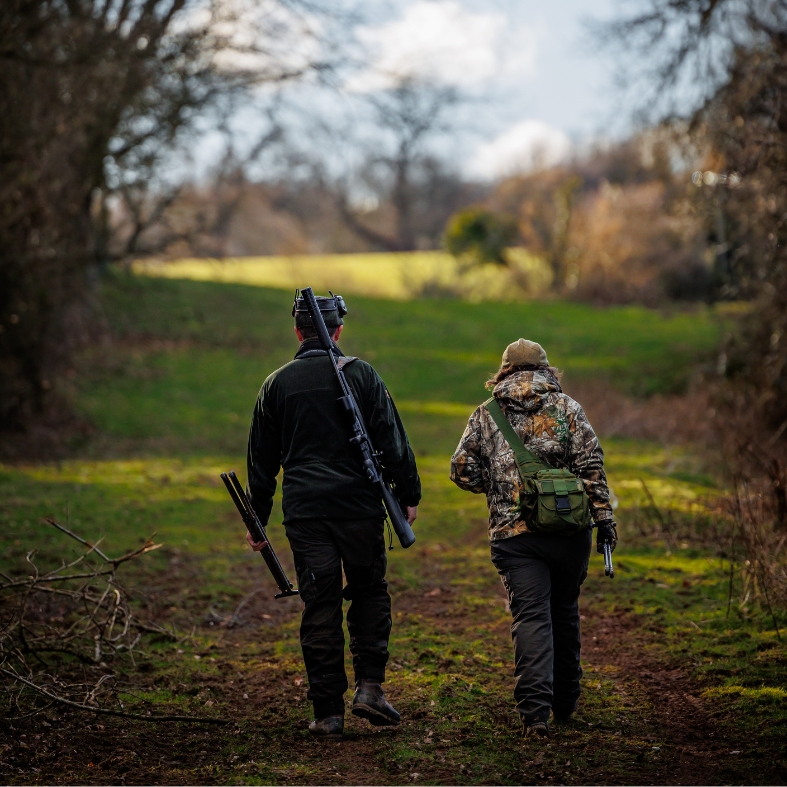 two people walking with rifle