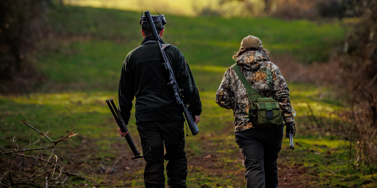 two people walking with rifle